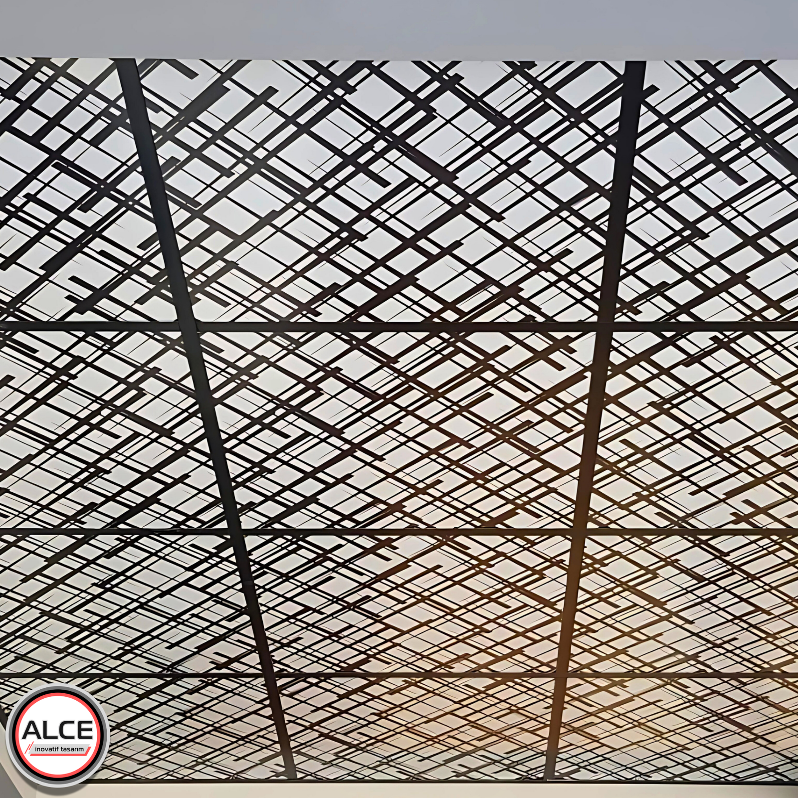Alce İnovatif Tasarım tarafından sunulan, banyo ve mutfak gibi ıslak hacimler için ideal, geometrik ve floral desenli PVC plastik asma tavan panellerinin görünür T-profil grid sistemindeki yakın plan görünümü.